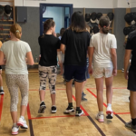 Jugendliche die gemeinsam mit dem Trainer die Fechthalle vom UFC-Wien verlassen.